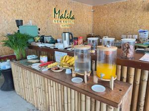 a counter with two glasses of orange juice on it at Malila Sea Breeze Hostel in Ko Tao
