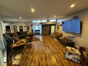 a living room with a large flat screen tv at Dock Holiday – The Keys Favorite | Wild West River Escape in Parker