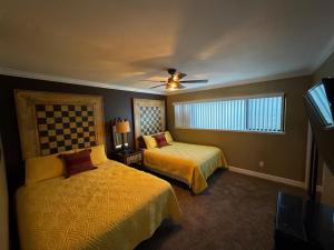 a bedroom with two beds and a ceiling fan at Dock Holiday – The Keys Favorite | Wild West River Escape in Parker