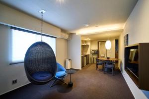 a living room with a swing chair and a table at HOTEL MASTAY jingumichi in Kyoto
