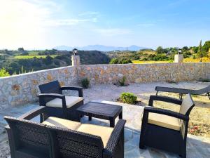 a group of chairs and tables and a stone wall at Glyki Canyon Bungalow in Antimácheia