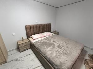 a bedroom with a large bed with a pink pillow at Glyki Canyon Bungalow in Antimácheia