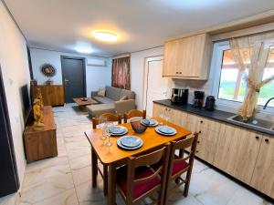 a kitchen and a dining room with a table and a kitchen and a living room at Glyki Canyon Bungalow in Antimácheia