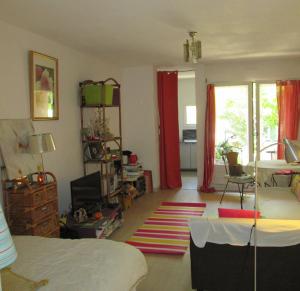 Un dormitorio con una cama y una sala de estar. en Joli studio avec jardinet, en Aviñón