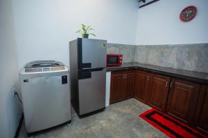 a kitchen with a refrigerator and a microwave at Noha Villa in Talpe