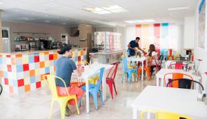 a group of people sitting at tables in a restaurant at Funway Academic Resort in Madrid