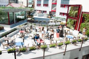 a rooftop patio with tables and chairs on a building at Funway Academic Resort in Madrid