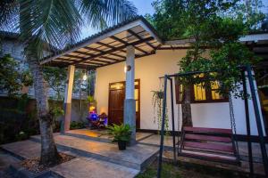 a house with a porch with a swing at Noha Villa in Talpe