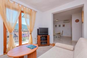 salon z kanapą, telewizorem i stołem w obiekcie MI Apartment w mieście Stari Grad