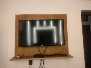 a television on a wooden shelf on a wall at Tapovan Lightning room by yog tapovan in Rishīkesh