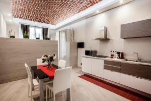 Torino Suite في تورينو: مطبخ وغرفة طعام مع طاولة وكراسي