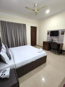 a bedroom with a bed and a desk with a computer at Hotel Fortune Home Residency Near Spectrum Mall Sector 72 in Noida