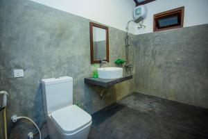 a bathroom with a toilet and a sink and a mirror at Noha Villa in Talpe +25 photos