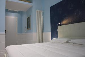 ローマにあるTuttelestrade - The apartmentのベッドルーム1室(青い壁の大きな白いベッド1台付)