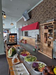 a kitchen with a table with many plates of food at Pine Tree Beach Hotel in Gili Trawangan