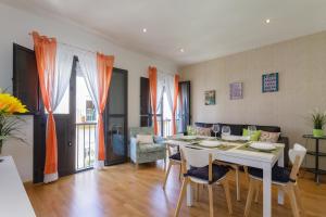 a dining room and living room with a table and chairs at Apartamento La PALMA free parking by Cadiz4Rentals in Cádiz