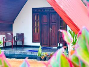 a front door of a house with chairs and plants at Sigiriya On Rock Villa in Sigiriya