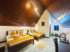 a bedroom with two beds and a wooden ceiling at Sigiriya On Rock Villa in Sigiriya +46 photos