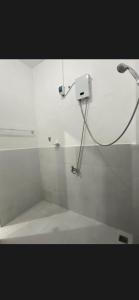 a white bathroom with a shower with aperature at Hidden Grove GuestHouse in General Luna