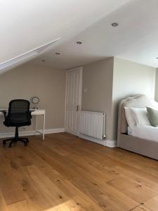 a bedroom with a bed and a desk and a chair at Modern Spacious 4 Bedroom Home in Greater LDN With Garden and Parking in Dartford +11 photos