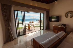 a bedroom with a bed and a view of the ocean at Vanara Resort and Spa in Uluwatu