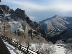 a view of a mountain range with snow and a fence at La Posada de Cucayo in Dobres