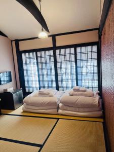 a bed in a room with large windows at Roman Kan in Kyoto