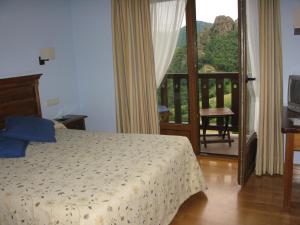 a bedroom with a bed and a balcony at La Posada de Cucayo in Dobres