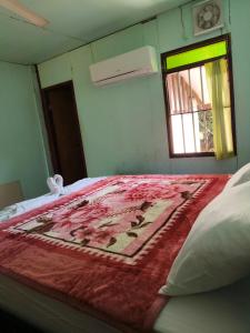 a bedroom with a bed with a red blanket on it at Noupad sunset Guesthouse in Don Det +11 photos