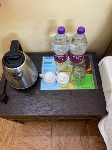 two bottles of water and a tea pot on a table at Hotel Baga Sea Blue in Baga