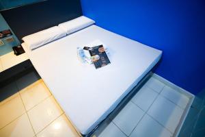 a white bed in a room with a blue wall at Astrotel Divisoria in Manila