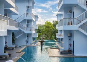 a pool in the middle of a building with white buildings at Arawan Beach Resort Krabi in Ao Nam Mao +53 photos
