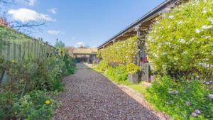 a gravel pathway in a garden with flowers at Nouvelle Studio in Epsom