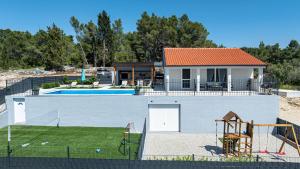 a house with a swimming pool next to a yard at Villa Antea by Villas Guide in Vela Luka