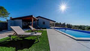 a backyard with a pool and a chair and a table at Villa Antea by Villas Guide in Vela Luka