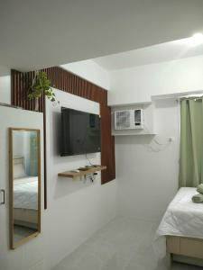 a white room with a tv and a mirror at Clover88 Studio Room is in the City but with a seaview in Mandaue City