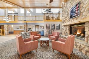 a lobby with chairs and a fireplace at AmericInn by Wyndham Bismarck in Bismarck