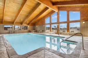 a swimming pool in a house with a wooden ceiling at AmericInn by Wyndham Bismarck in Bismarck