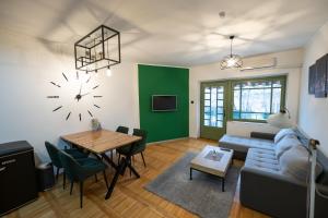 a living room with a table and a clock on the wall at Srafko apartment in Subotica