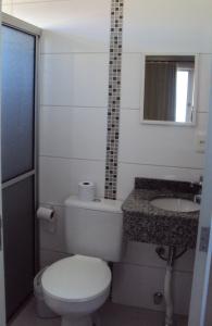 a small bathroom with a toilet and a sink at Pousada Dona Luiza in Carlos Barbosa