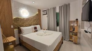 a bedroom with a bed in a room with a television at SilverLeaf in El Nido +24 photos