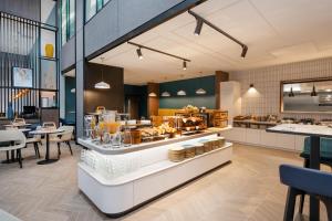 a restaurant with a counter with a lot of food at Hyatt Place Leeds in Leeds