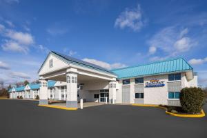 a large white building with a blue roof at Baymont by Wyndham Westampton in Westampton Township