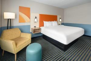 a hotel room with a bed and a chair at Baymont by Wyndham Westampton in Westampton Township +37 photos