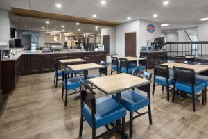 a restaurant with tables and chairs and a kitchen at Baymont by Wyndham Westampton in Westampton Township