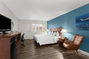 a hotel room with a bed and a television at PaddleTail Waterfront Lodge, Trademark Collection by Wyndham in Crystal River +53 photos