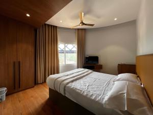 a bedroom with a bed and a ceiling fan at Cloud Nine Hotel in Kottayam