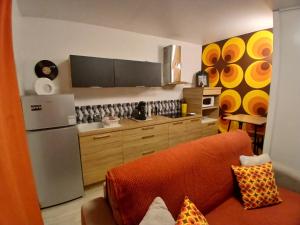 a kitchen with an orange couch and a refrigerator at Studio POP Canet En Roussillon in Canet-en-Roussillon