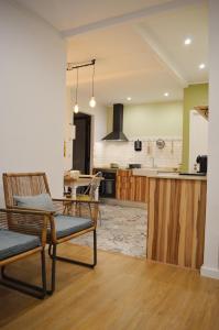 Il comprend un salon avec deux chaises et une cuisine. dans l'établissement T2P Félix House, à Vila Nova de Gaia