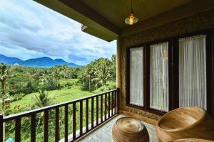 a room with a balcony with a view of the mountains at Four Mountains Villa Bedugul by AGATA in Bedugul